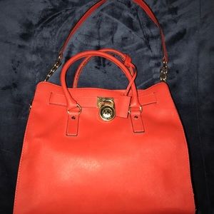 A orange leather Michael Kors tote bag